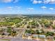 Aerial view of a neighborhood featuring a mix of homes surrounded by trees and foliage under a blue sky filled with puffy clouds at 12470 Elgin Blvd, Spring Hill, FL 34609