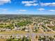 Aerial view of the neighborhood showcasing the residential area with green spaces and roadways under a partly cloudy sky at 12470 Elgin Blvd, Spring Hill, FL 34609