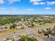 An aerial view of a neighborhood with homes and trees under a bright blue sky at 12470 Elgin Blvd, Spring Hill, FL 34609