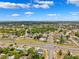 Aerial view of a sunny suburban neighborhood with many trees and an intersection at 12470 Elgin Blvd, Spring Hill, FL 34609