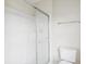 Bathroom features a glass door shower, toilet, and white tile at 12470 Elgin Blvd, Spring Hill, FL 34609