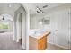 Bathroom sink with white countertop, cabinets, and an arched doorway into the hallway at 12470 Elgin Blvd, Spring Hill, FL 34609