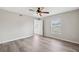 Bedroom with new wood floors and natural light with a ceiling fan and two windows at 12470 Elgin Blvd, Spring Hill, FL 34609