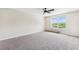 Bedroom with carpet, a ceiling fan, and a window looking out onto greenery at 12470 Elgin Blvd, Spring Hill, FL 34609