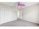 A simple bedroom with gray carpet, white walls, and a purple leaf fan above at 12470 Elgin Blvd, Spring Hill, FL 34609