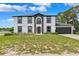 Charming two-story home with a dark accent trim, arched window, well-maintained lawn, and attached two car garage at 12470 Elgin Blvd, Spring Hill, FL 34609