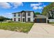 Attractive 2-story home featuring a well-manicured front lawn, dark trim, an arched window, and an attached two-car garage at 12470 Elgin Blvd, Spring Hill, FL 34609