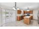 Kitchen with stainless appliances, wood cabinets, an island, tiled floors, and a sliding glass door at 12470 Elgin Blvd, Spring Hill, FL 34609