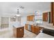 Kitchen with stainless appliances, wood cabinets, an island, and tiled floors at 12470 Elgin Blvd, Spring Hill, FL 34609