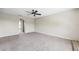 Living room with gray carpet, arched doorways, and a ceiling fan at 12470 Elgin Blvd, Spring Hill, FL 34609