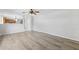 Living room with wood flooring, a ceiling fan, and an opening into the kitchen at 12470 Elgin Blvd, Spring Hill, FL 34609