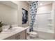 Modern bathroom with a vanity, framed mirror, a stylish blue shower curtain, and clean fixtures at 12842 Canter Call Rd, Lithia, FL 33547