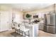 Modern kitchen featuring stainless steel appliances, an island with seating, and gray cabinets at 12842 Canter Call Rd, Lithia, FL 33547