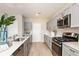 Kitchen featuring quartz countertops, stainless steel appliances and gray cabinets with a view into the dining area at 12842 Canter Call Rd, Lithia, FL 33547