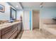 Bathroom with granite countertop, wood cabinets and a walk-in shower with separate tub at 14169 Fennsbury Dr, Tampa, FL 33624