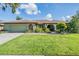 Charming single-story home with well-manicured lawn, lush landscaping, and an attached two-car garage at 14169 Fennsbury Dr, Tampa, FL 33624