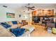 Relaxing living room featuring a large sectional sofa, unique stone fireplace, and a ceiling fan at 14169 Fennsbury Dr, Tampa, FL 33624
