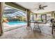 Enclosed pool area features a pool, water feature, ceiling fan, outdoor seating, and tiled flooring at 14169 Fennsbury Dr, Tampa, FL 33624