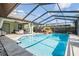 Enclosed pool area features a pool, water feature, ceiling fan, outdoor seating, and landscaped perimeter at 14169 Fennsbury Dr, Tampa, FL 33624