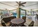 Spacious sunroom with multiple ceiling fans, a ping pong table, and access to the screened pool area at 14169 Fennsbury Dr, Tampa, FL 33624