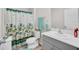 Well-lit bathroom features a single sink, decorative towels, and a patterned shower curtain at 14643 Brumby Ridge Ave, Lithia, FL 33547