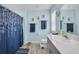 Bright bathroom with a single sink vanity, decorative towels and a blue shower curtain at 14643 Brumby Ridge Ave, Lithia, FL 33547