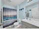 Bathroom with a single sink vanity, decorative towels and a beach themed shower curtain at 14643 Brumby Ridge Ave, Lithia, FL 33547