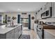 Open kitchen with gray cabinets, island, modern appliances, and outdoor access at 14643 Brumby Ridge Ave, Lithia, FL 33547