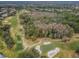 An aerial perspective captures the golf course, woods, and charming residential area blending nature with community living at 1516 E Lake Woodlands Pkwy, Oldsmar, FL 34677