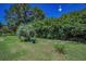 The home features a well-maintained lawn, mature landscaping, creating a serene outdoor setting at 1516 E Lake Woodlands Pkwy, Oldsmar, FL 34677