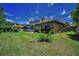 The home features a well-maintained lawn, mature landscaping, and a screened lanai at 1516 E Lake Woodlands Pkwy, Oldsmar, FL 34677