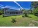 The home features a well-maintained lawn, mature landscaping, and a screened pool at 1516 E Lake Woodlands Pkwy, Oldsmar, FL 34677