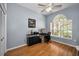 Bright bedroom featuring a ceiling fan, hardwood floors, and a large window at 1516 E Lake Woodlands Pkwy, Oldsmar, FL 34677