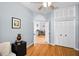 Bedroom featuring hardwood floors, a ceiling fan, and a doorway to another room at 1516 E Lake Woodlands Pkwy, Oldsmar, FL 34677