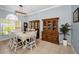 Traditional dining room boasts ample sunlight, built-in china cabinets, and tiled flooring at 1516 E Lake Woodlands Pkwy, Oldsmar, FL 34677