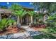 Charming single-story house featuring a landscaped yard, a tiled roof, and a front door at 1516 E Lake Woodlands Pkwy, Oldsmar, FL 34677