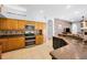 Well-lit kitchen featuring a double oven, wooden cabinets, and granite countertops for a functional cooking space at 1516 E Lake Woodlands Pkwy, Oldsmar, FL 34677