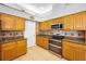 Modern kitchen with stainless steel appliances, wooden cabinets, and tiled backsplash for a stylish cooking space at 1516 E Lake Woodlands Pkwy, Oldsmar, FL 34677