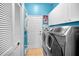 Bright laundry room with modern washer/dryer and storage cabinets at 1516 E Lake Woodlands Pkwy, Oldsmar, FL 34677