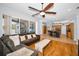 Inviting living room with hardwood floors, a ceiling fan, and an open view of the kitchen and lanai at 1516 E Lake Woodlands Pkwy, Oldsmar, FL 34677