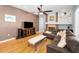 Cozy living room features a fireplace, ceiling fan, and hardwood floors at 1516 E Lake Woodlands Pkwy, Oldsmar, FL 34677