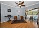 Sun-filled sitting room with wood floors and sliding glass doors that lead to a pool at 1516 E Lake Woodlands Pkwy, Oldsmar, FL 34677