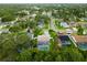 A bird's-eye perspective showing the properties, swimming pools, and tree canopies at 1562 Coastal Pl, Dunedin, FL 34698