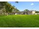 Expansive backyard featuring a screened-in pool area and lush green lawn, perfect for outdoor activities at 1562 Coastal Pl, Dunedin, FL 34698