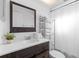 Well-lit bathroom with a wood framed mirror and vanity, a white countertop, and towel storage at 1562 Coastal Pl, Dunedin, FL 34698