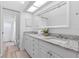 Bathroom featuring double sinks with granite countertops and white cabinetry offering style and functionality at 1562 Coastal Pl, Dunedin, FL 34698