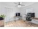 Bright bedroom with stylish ceiling fan, wood floors, large closet, and modern desk setup at 1562 Coastal Pl, Dunedin, FL 34698