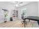 Bright bedroom features stylish light fixture, wood floors, and bookshelves at 1562 Coastal Pl, Dunedin, FL 34698