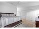 Spacious bedroom with a king bed, light plank flooring, double closets, and neutral decor for a relaxing atmosphere at 1562 Coastal Pl, Dunedin, FL 34698