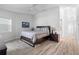 Serene bedroom features light plank flooring, a ceiling fan, and a king-size bed with neutral bedding at 1562 Coastal Pl, Dunedin, FL 34698